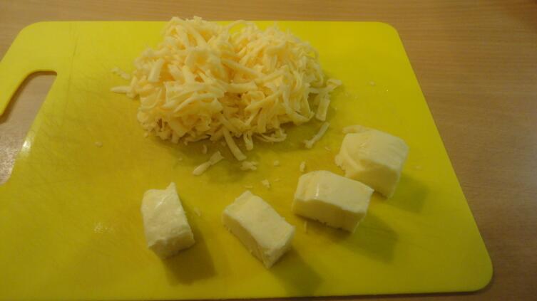 В каждый из горшочков нужно положить по небольшому кусочку сливочного масла и сверху присыпать его тертым сыром