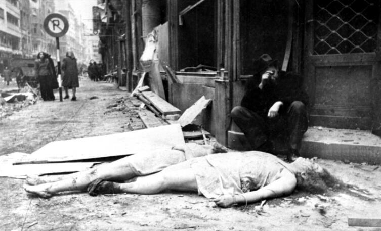 Мужчина возле тел убитых женщин в освобожденном будапештском гетто. Более 220 тысяч будапештских евреев при фашистском режиме были перемещены в гетто