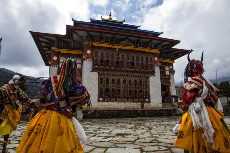 Монахи танцуют во время фестиваля Цечу Ура в долине Бумтанг в Бутане