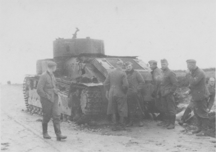 Немецкие солдаты рассматривают подбитый и сгоревший советский танк Т-28