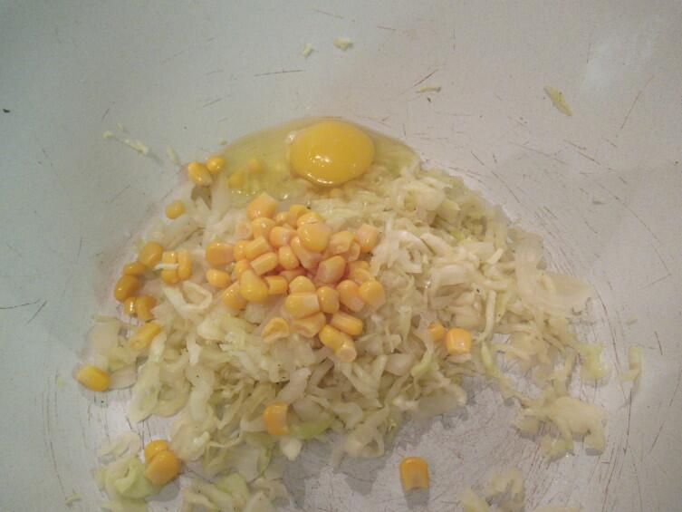 Добавляем к капусте столовую ложку консервированной кукурузы, сырое яйцо…