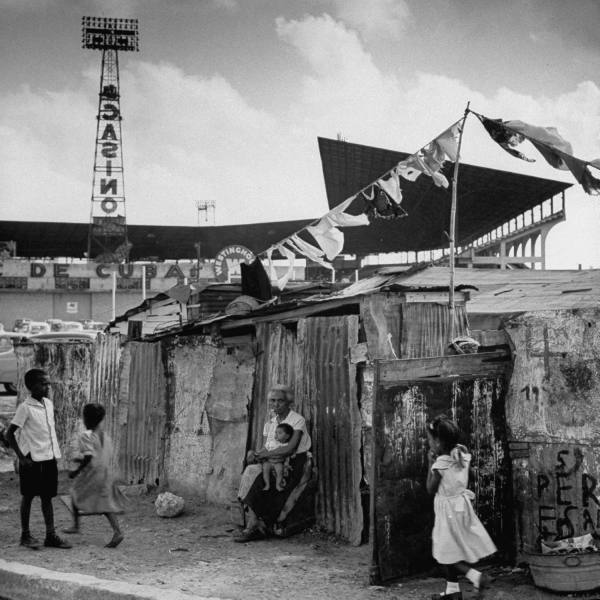 Трущобы в Гаване, неподалеку от бейсбольного стадиона. На заднем плане реклама близлежащего казино, 1954 г.
