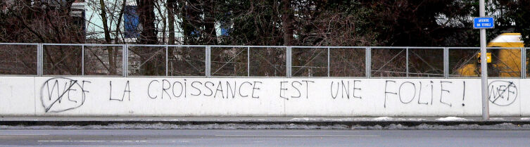 Антиглобалистское граффити в Лозанне: зачёркнута эмблема Всемирного экономического форума (WEF) и прибавлены слова: «Рост — это безумие!»