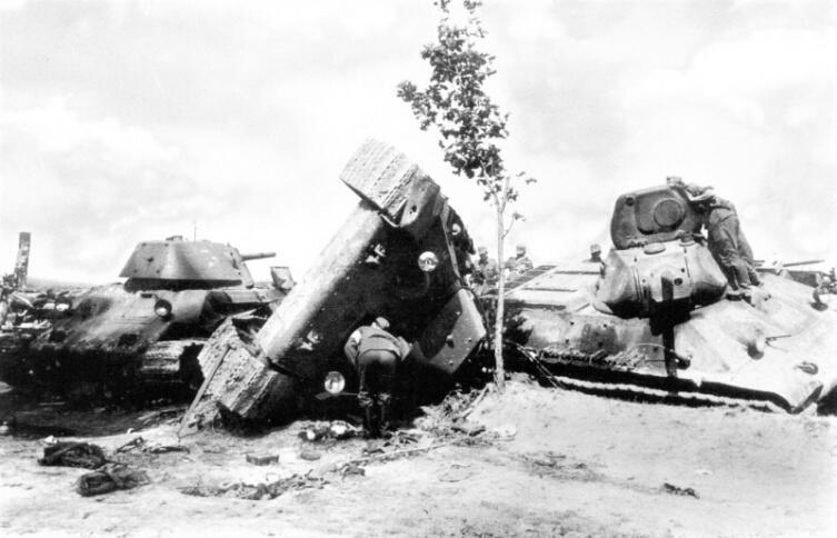 Солдаты вермахта осматривают танки Т-34 32-й танковой дивизии РККА, попавшие под авиаудар на дороге в районе Язова Старого 