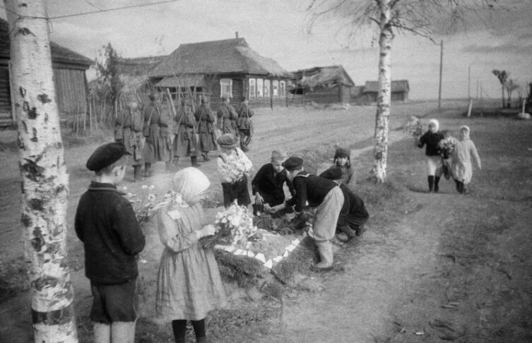 Дети возлагают цветы на могилы советских бойцов, павших в боях за освобождение Ржева