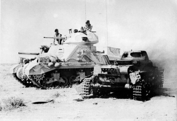 Британские танкисты проезжают на танке М3 «Грант» мимо подбитого немецкого танка Pz.I
