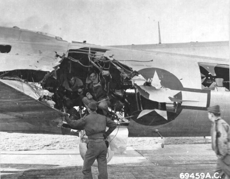 Экипаж американского бомбардировщика B-17 осматривает повреждения своего самолета после налета на Мюнхен